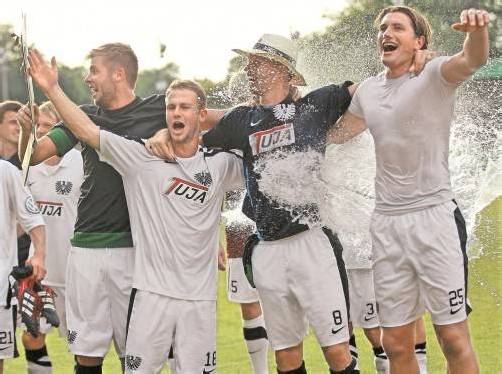Die Spieler von Preußen Münster feiern den Cup-Erfolg. Foto: ap