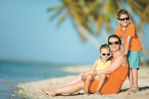 Beautiful mother and two kids enjoying beach vacation