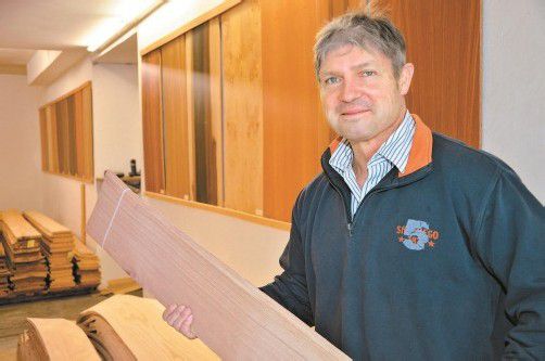 Firmeninhaber Gerhard Mäser im Lager mit einem Bündel Furniere in der Hand. Foto: vn/Tobias Hämmerle