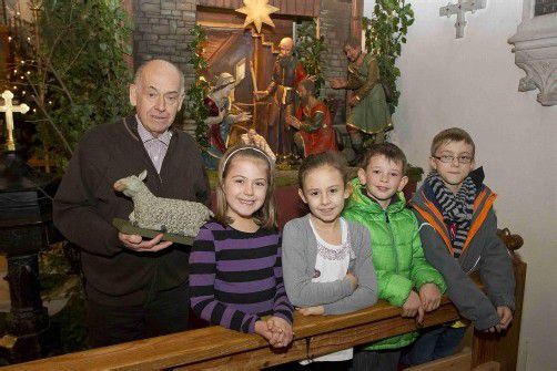Russ-Preis-Träger Walter Fehle zeigt Julia, Elena, Leon und Christoph Vorarlbergs älteste Krippe. Sie steht über Weihnachten in Meschach. Foto: VN/Paulitsch