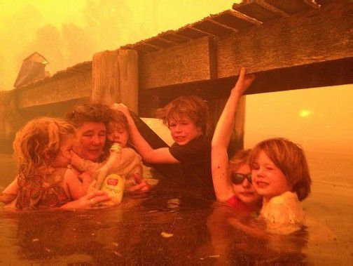 Binnen weniger Minuten war diese australische Familie von den Flammen umzingelt. Ihr einziger Fluchtweg: das Meer. Foto: AP