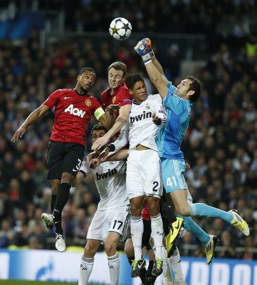 Manchester United’s Patrice Evra (l.) und Jonny Evans bedrängen Real Madrid’s Raphael Varane und Torhüter Diego Lopez. Foto: ap