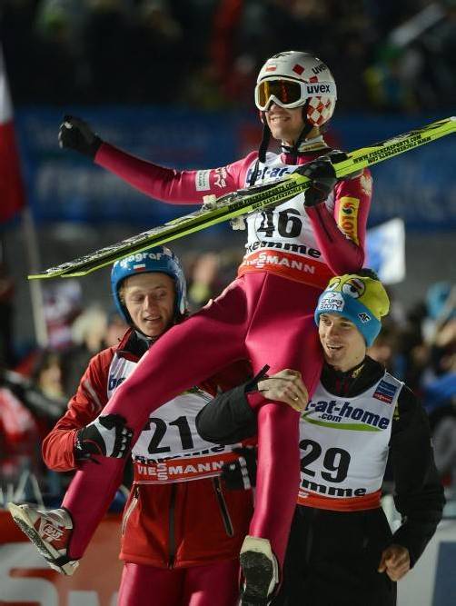 Kamil Stoch wird nach seinem Siegsprung von seinen polnischen Teamkollegen Piotr Zyla (r.) und Dawid Kubacki (l.) gefeiert. Foto: epa