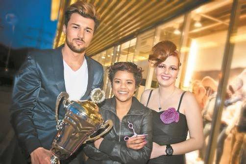 Strahlende Siegerin: Janine Lässer (Mitte) mit ihren Frisurenmodellen und Pokal. Foto: Stiplovsek