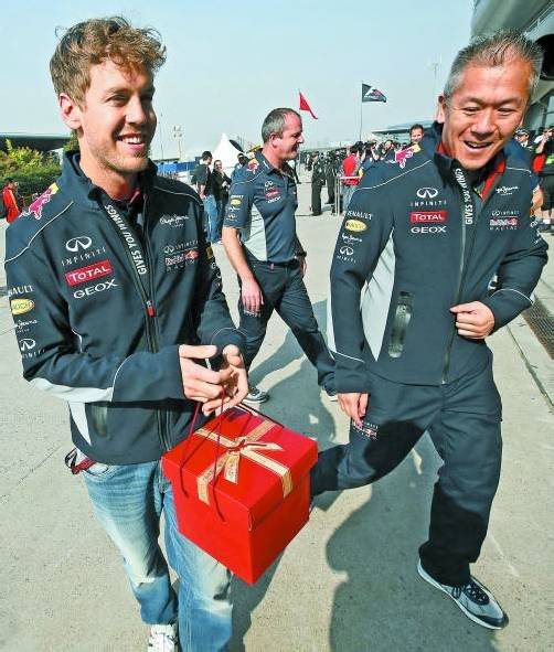 Sebastian Vettel mit einem Geschenkspaket in Schanghai – es dürfte nicht an die Adresse von Mark Webber gegangen sein. Foto: reuters