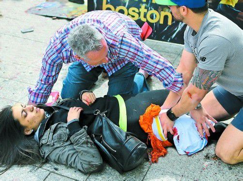 Sekunden nach dem Anschlag beim traditionsreichen Boston-Marathon: Zuschauer helfen einander, nachdem zwei Sprengkörper mit Metallsplittern, Nägeln und Kugellagern explodiert waren. Foto: Reuters