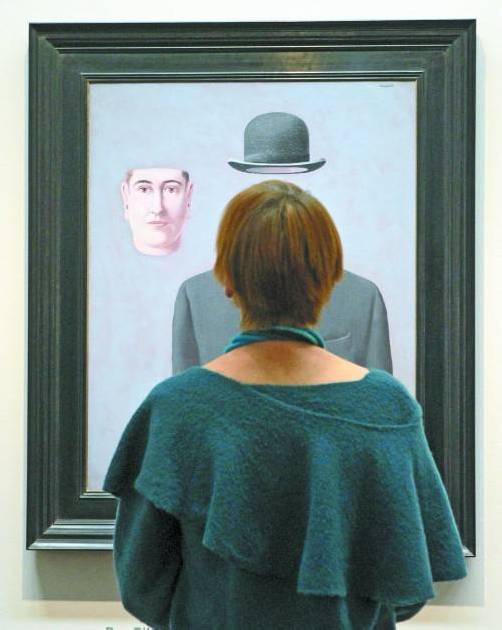 Eine Frau betrachtet das Bildnis „Le Pèlerin“ des bekannten belgischen Surrealisten René Magritte. Foto: Reuters