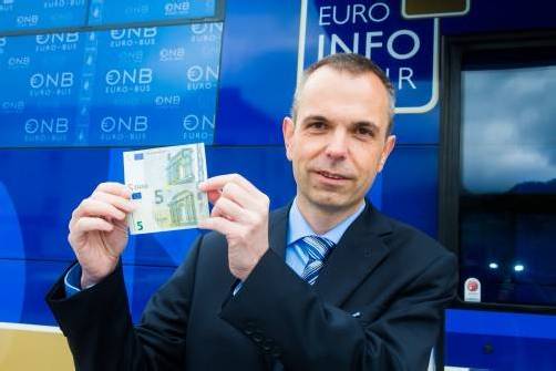 Nationalbank-West-Chef Armin Schneider mit altem und neuem Fünfer vor dem Euro-Bus. Foto:VN/Steurer