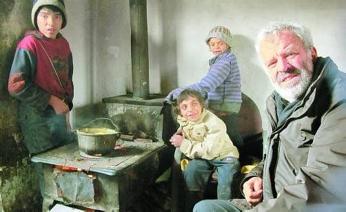 Jesuitenpater Georg Sporschill mit Roma-Kindern in einer Hütte im rumänischen Ort Ziegental. Foto: Sporschill