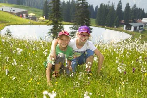 Die Geschwister Constantin und Katharina aus Fußach rasten auf der Blumenwiese beim Speichersee.