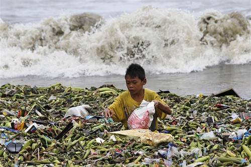 Im angespülten Müll sucht dieser kleiner Junge nach Wiederverwertbarem, das er verkaufen kann. Foto: REUTERS