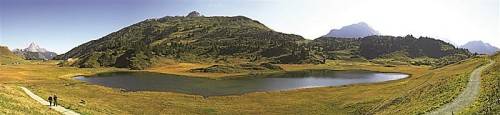 Viele Wanderer genießen die Landschaft am Kalbelesee inmitten der Lechtaler Alpen. Der kleine See wird umrahmt von Auenfelder Horn, Saloberkopf und Juppenspitze.