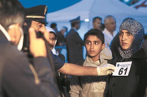 Flüchtlinge aus Syrien und Palästina werden nach ihrer Ankunft in Sizilien mit einer Nummer versehen und fotografiert. Legal könnten sie nicht einreisen, um Asyl zu beantragen. Foto: RTS