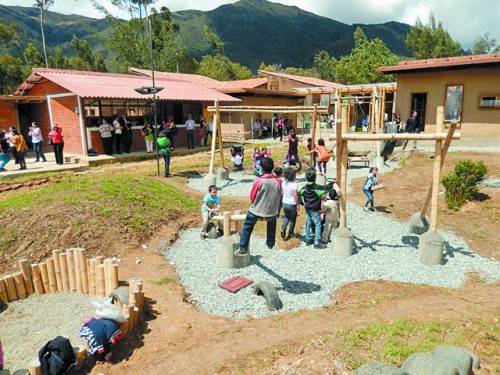 Kinder auf dem neuen Spielplatz – im Hintergrund der Neubau.