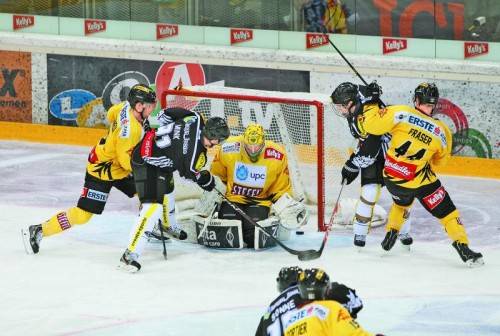 So war es im ersten Spiel beim 4:3-Sieg der Bulldogs: Graham Mink hat die Lücke gefunden und schiebt den Puck an Torhüter Matt Zaba vorbei zur 4:2-Führung. Peter Schweda (v. l.), Luciano Aquino (Dornbirn) und Jamie Fraser sind Zuschauer. Foto: gepa