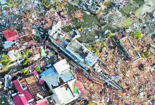 Was der Taifun „Haiyan“ mit Windspitzen von 380 km/h angerichtet hat: Ein Schiff steht in einer verwüsteten Siedlung von Tacloban. Foto: EPA