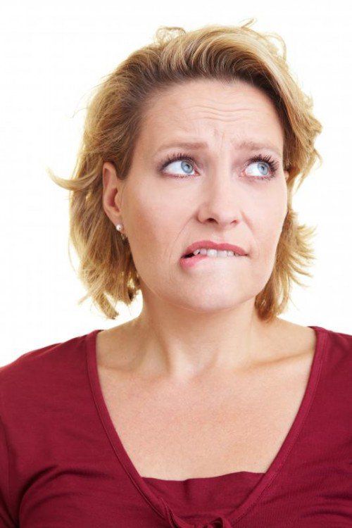 Blonde Frau beißt sich auf die Lippen