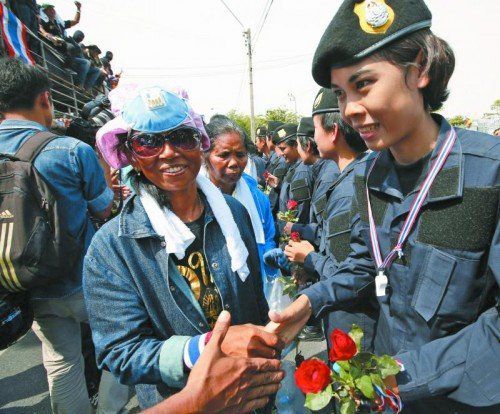 Staatsmacht wechselt Strategie: Die thailändische Polizei baute Barrikaden ab und verteilte Rosen. Foto: EPA