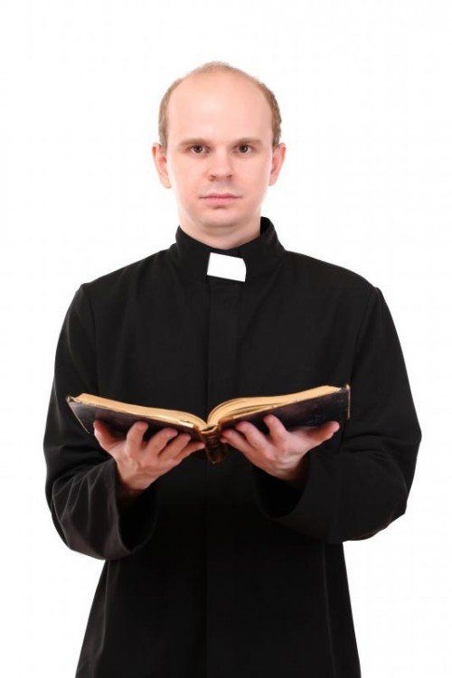 Young pastor with Bible, isolated on white