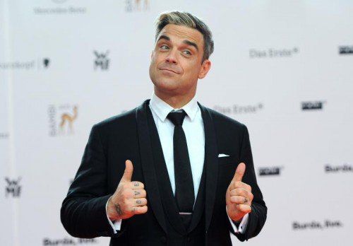ARCHIV - Der britische Sänger Robbie Williams kommt am 14.11.2013 zur 65. Bambi-Verleihung im Stage-Theater am Potsdamer Platz in Berlin. Robbie Williams findet sich selber zur Hälfte homosexuell. «Ich bin zu 49 Prozent schwul», sagte er dem Schwulenmagazin «Männer» (Dezember). Foto: Britta Pedersen/dpa +++(c) dpa - Bildfunk+++