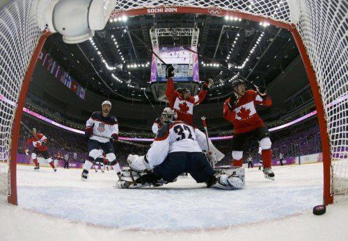 Kanadas Jamie Benn, hinter US-Torhüter Jonathan Quick bejubelt den Siegestreffer für Kanada. Weiter im Bild: Brooks Orpik (l.) und Corey Perry (r.). Foto: Reuters
