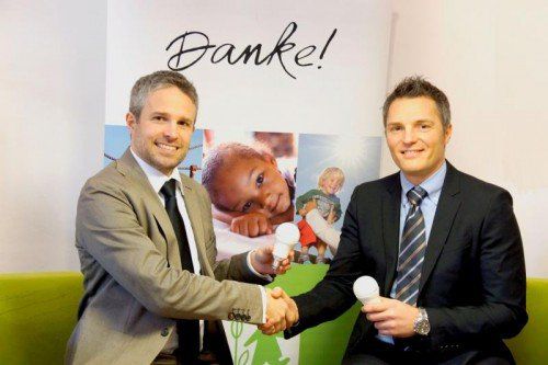 Mit der Übergabe zweier LED-Lampen besiegeln Stephan Haupt von Tridonic (r.) und Wolfgang Katsch von SOS-Kinderdorf die Aktion.
