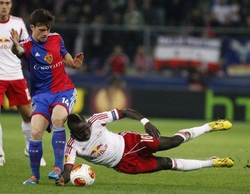 Basels Valentin Stocker (links) im Kampf um den Ball mit dem Salzburger Sadio. Das kleine Bild zeigt die Feuer im Basler Fansektor. Fotos: Reuters, ap
