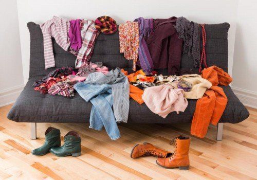 What to wear? Messy colorful clothing on a sofa.
