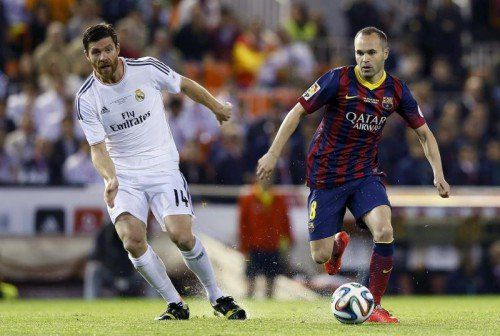 Andrés Iniesta (im Bild rechts gegen Reals Xabi Alonso) steht im Mittelpunkt des Gewinnspiels von Powerade. Foto: epa