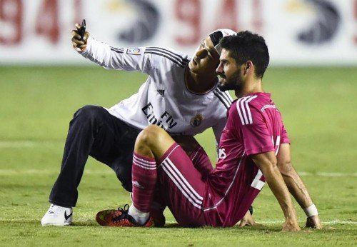 Ein Fan hat es auf den Platz des Cotton-Bowl-Stadions geschafft und Real-Akteur Isco für ein „Selfie“ überredet. Foto: epa