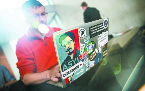 NSA-Aufdecker Edward Snowden: Abbildung von ihm auf einem Laptop, den ein Journalist im Deutschen Bundestag einsetzt. Foto: DPA