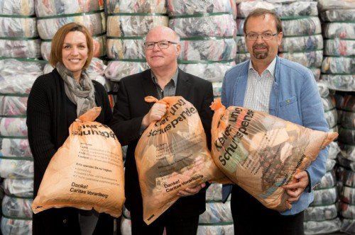 Karoline Mätzler, Peter Klinger und Rainer Siegele mit dem neuen orangen Sack für Kleiderspenden. Foto: VN/ds