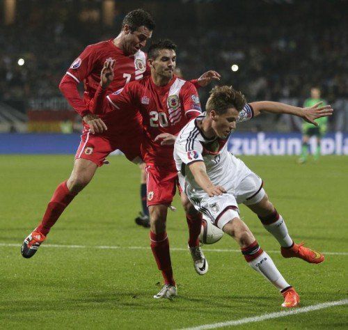 Deutschlands Erik Durm (rechts) versucht sich gegen gegen Jean Garcia (Mitte) und Lee Casciaro durchzusetzen. Foto: ap