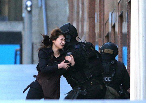 Dramatische Augenblicke in Sydney: Eine Geisel rettet sich in die Arme eines Polizisten. Beim späteren Sturm auf das Café Lindt sterben der Kidnapper und zwei Geiseln. FOTO: AP