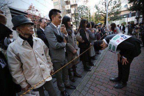 Wahlkampf auf japanisch: Ein Werber für die Liberal-Demokratische Partei (LDP) bittet um Stimmen. FOTO: AP