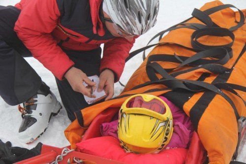 Ein Alpinpolizist mit einem verletzten Snowboarder bei der Unfallaufnahme.  Foto: VOL.AT/Schwendinger  