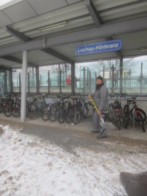 Ein Bauhofmitarbeiter streut Kies auf den rutschigen Boden vor dem Bahnhof Lochau-Hörbranz. Foto: bms