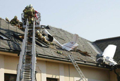 ABD0142_20150318 - KLAGENFURT - ÖSTERREICH: ZU APA0373 VOM 18.3.2015 - Bei dem Absturz eines Leichtflugzeuges im Norden von Klagenfurt sind am Mittwoch, 18. März 2015, beide Insassen getötet worden. Die Maschine stürzte in das Dach eines landwirtschaftlichen Nebengebäudes. Im Bild: Einsatzkräfte der Feuerwehr an der Unglücksstelle. - FOTO: APA/GERT EGGENBERGER