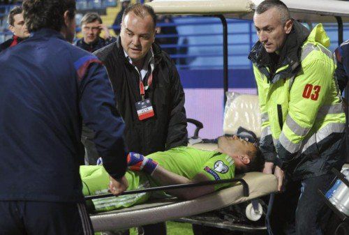 Der von einem Feuerwerkskörper (kl. B.) getroffene russische Goalie Igor Akinfejew wird abtransportiert. Reuters
