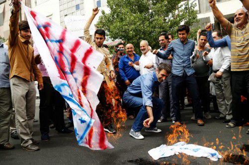 Selbstgefertige Flaggen der USA und Israels brennen: Im Iran mehrt sich Protest gegen Atomverhandlungen.  EPA