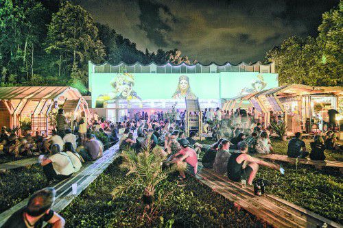 Der atmosphärischen Außenbereich und die Holz-Architektur des heurigen Poolbar-Festivals bei Abendstimmung.