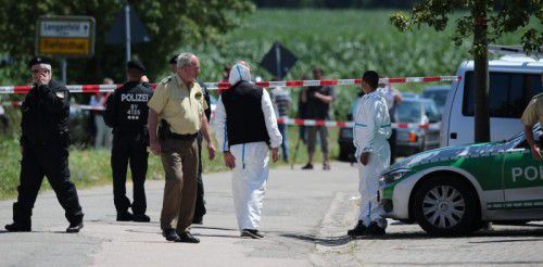 Polizisten und Mitarbeiter der Spurensicherung untersuchen den Tatort in Leutershausen. Foto: EPA
