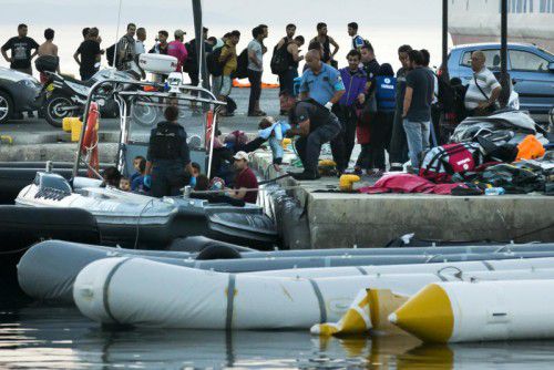 Einsatzkräfte der Küstenwache holen am Montag erneut aus dem Mittelmeer gerettete Flüchtlinge im Hafen von Kos sicher an Land.