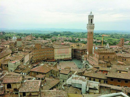 Der Piazza del Campo befindet sich im Herzen der Stadt Siena und lockt Touristen, Einheimische und Straßenkünstler an.