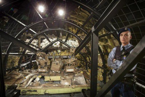 Ein Militärpolizist bewacht das zerstörte Cockpit von Flug MH17, welches der Öffentlichkeit bei der Präsentation des Abschlussberichts präsentiert wurde.