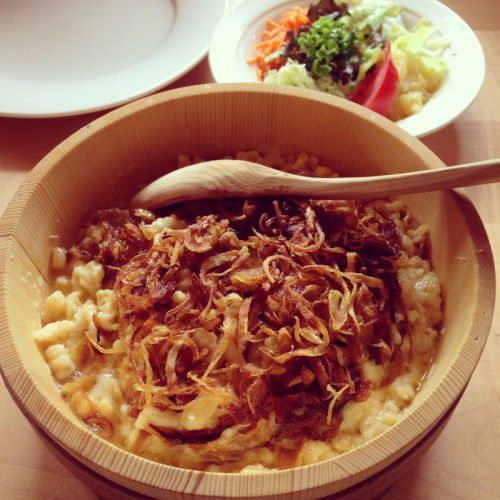 Die Kässpätzle werden in der traditionellen Holzgebse serviert. 