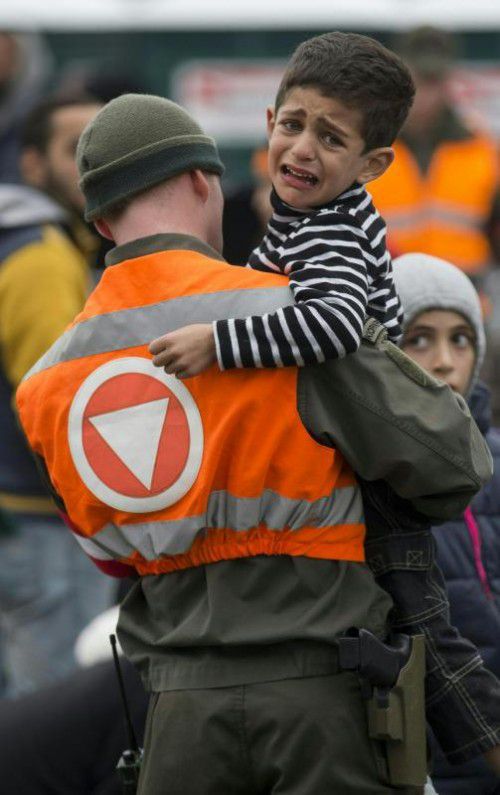 Ein Flüchtlingskind und ein Soldat im Oktober an der slowenisch-österreichischen Grenze in Spielfeld.