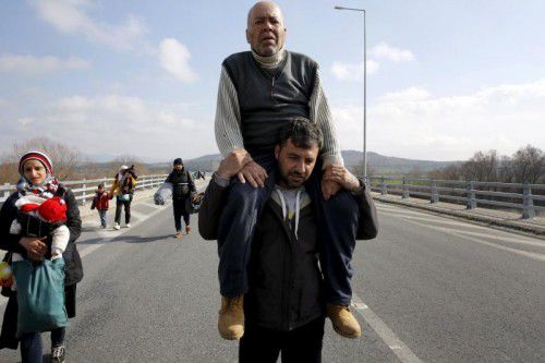 Flüchtlinge gehen auf griechischen Straßen zur mazedonischen Grenze. Dort warten bereits 20.000 Menschen auf ihre Weiterreise.