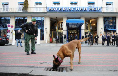 Mithilfe eines „Schnüffelhundes“ inspiziert die Polizei das Gelände um den Bayerischen Hof, den Tagungsort der Sicherheitskonferenz.