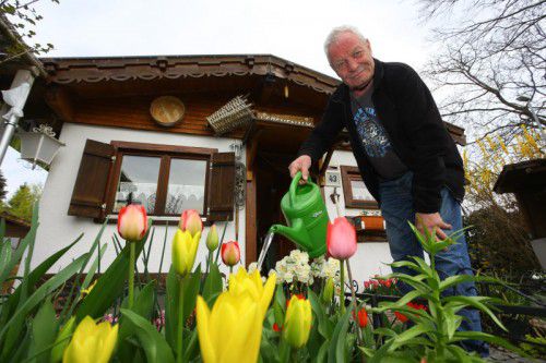 Walter Medwed gießt die Blumen. Im Frühling hat er vor seiner Hütte ein richtiges Blütenmeer.